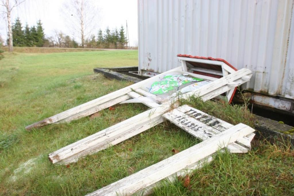 “Tas salūza, sapuva un nokrita. Zemē nomests tas jau tur atrodas apmēram gadu. Tā kā neviens netaisīja un mums jau tas nav jāuzstāda, mēs to nolikām aiz konteineriem,” stāsta degvielas uzpildes stacijas 