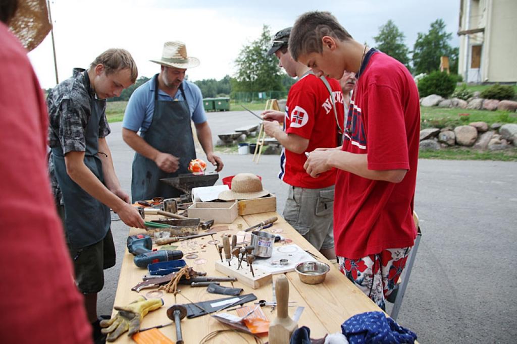 Metālmākslinieks Mārcis Mūrnieks (no labās) ar saviem palīgiem ierādīja, kā izgatavojama Tirzas sakta, poga ar Tirzas ģerboni, aproce vai gredzens. “Viss dzīvē ir “izkaļams”,” uzskata mākslinieks.
Autors: Gatis Bogdanovs
