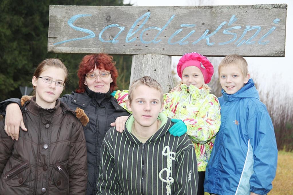  Dace Ostrovska no Stāmerienas pagasta Kalnienas, kopā ar vīru audzina desmit bērnus.  Fotografēšanās brīdī visus “Saldūkšņu” mājas iemītniekus satikt neizdevās. Tas iespējams tikai svētkos, jo vecākie bērni dažādās skolās mācās arodus, daži, izmantojot rudens brīvdienas, bija devušies uz Kalnienas bibliotēku pasērfot internetā, arī tētis Ainārs todien atradās darba meklējumos, tāpēc fotografēšanās brīdī klāt bija tikai māmiņa Dace, meita Līva (no kreisās), priekšplānā dēls Alvis, aiz viņa brālis Raitis un mazā Katrīna.
Autors: Gatis Bogdanovs 