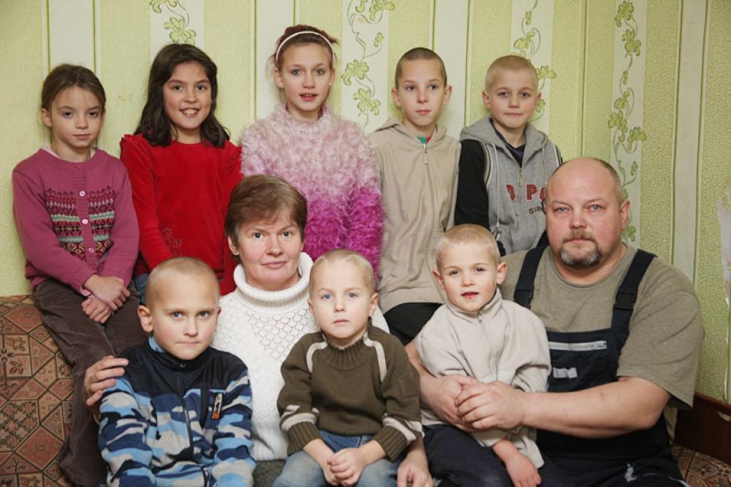 Visi kopā.  Audžutētim Guntim klēpī – piecus gadus vecais Valentīns, audžumammai Daigai – četrus gadus vecais Deniels, blakus septiņus gadus vecais Toms. Otrajā rindā (no labās) desmit gadus vecais Ruslans, vienpadsmit gadus vecais Ritvars, divpadsmit gadus vecā Karīna, deviņus gadus vecā Daniela un septiņus gadus vecā Ramira.
Autors: Gatis Bogdanovs 