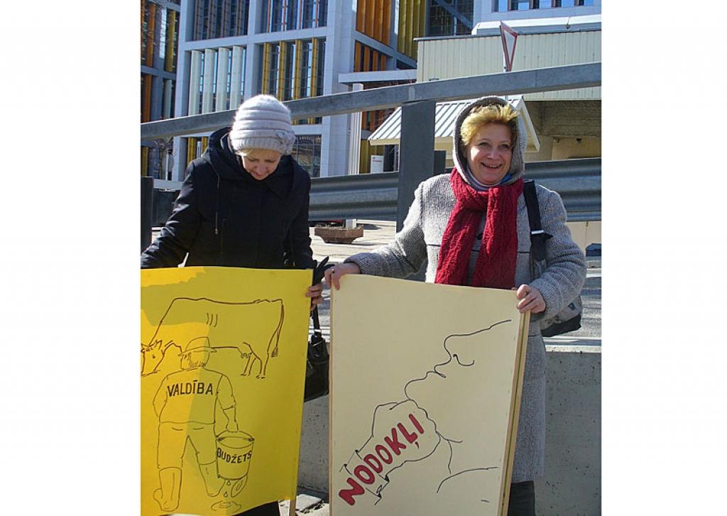 Daudzi protesta akcijas dalībnieki bija sagatavojuši arī plakātus. Starp tiem bija arī Gulbenes novada pārstāve Daukstu pagasta zemniece Olita Keibeniece (no labās). 
Autors: Sofija Sudarova