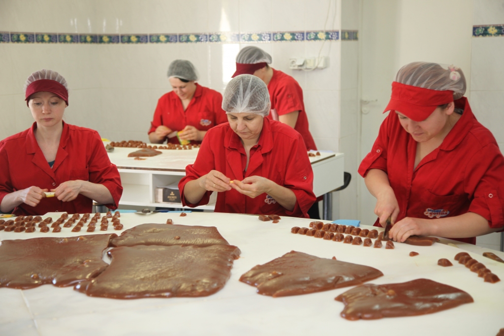 SIA „Skrīveru saldumi” Lizuma konfekšu cehā jau valda Līgosvētku noskaņa, jo tiek vārītas un fasētas konfektes „Gotiņa”, kuru ietinamos papīrus rotā nerātnās latviešu tautas dziesmas. Kopumā izraudzītas 32. Konfekšu tinējas joko, ka pašām no galvas gan neesot laika tās mācīties, jo vienā maiņā jāpaspējot satīt lielu daudzumu saldā kāruma, kas gatavots tikai bioloģiskā piena un dabīgām piedevām. Tieši tāpēc bioloģisko „Gotiņu” masa ir mazliet tumšāka. 	
Autors: Gatis Bogdanovs