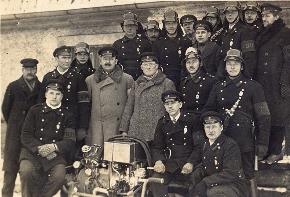 Vecgulbenes BUB ugunsdzēsēju komanda pie motorsūkņa divdesmito gadu beigās. No kreisās puses otrajā rindā otrais - ugunsdzēsēju komandas nodaļas vadītājs Jānis Briedītis. 	                   Foto: 
Autors: no GVMM krājuma