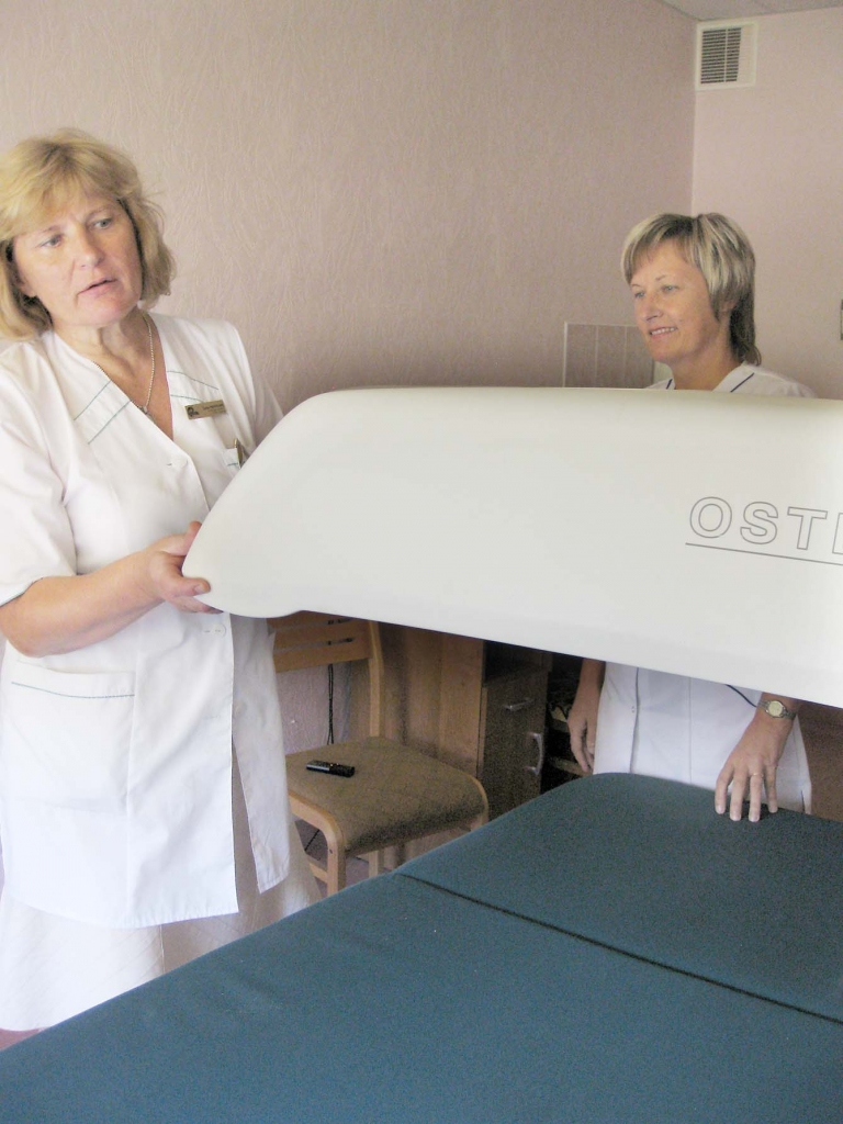 Mediķes Ženija Priedeslaipa (no kreisās) un Marina Zaķe stāsta, ka pirms osteodensitometrijas izmeklējuma veikšanas pacients tiek nomērīts un nosvērts. Vienīgais, kas pacientam jādara izmeklējuma laikā – mierīgi jāguļ. Savukārt šo izmeklējumu veikt uz savu galvu bez speciālista vai ģimenes ārsta nosūtījumu viņas neiesaka, jo, lai arī minimāls, tomēr tiek saņemts starojums.				                            
Autors:  Inita Savicka