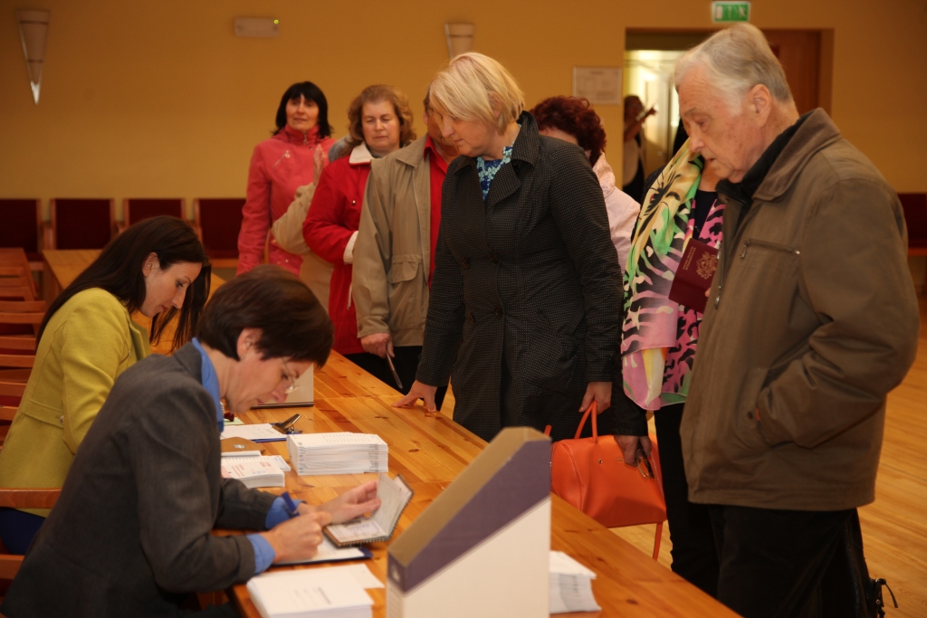 Pati pirmā Gulbenē 1.oktobrī savu balsi glabāšanā nodeva lizumniete Elita Dūte (centrā). Pirms iecirkņa atvēršanas pie tā jau bija izveidojusies vēlētāju rinda. Iepriekšējiem balsotājiem vienu reizi ir tiesības grozīt balsojumu, bet tikai vēlēšanu dienā un tikai Gulbenes iecirknī.  
Autors: Gatis Bogdanovs