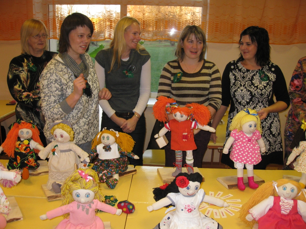 “Vienmēr, kad pabeidzu darināt kārtējo lelli, skatos kalendārā. Tā lelle dabū vārdu. Man ir jautājuši, ko daru, ja todien kalendārā ir vīrieša vārds. Atbildu, ka reti kad vīrietis ir viens pats – pat kalendārā. Vienmēr ir kāda dāma blakus!” saka Evita Zālīte (priekšplānā).  
Autors: Diāna Odumiņa