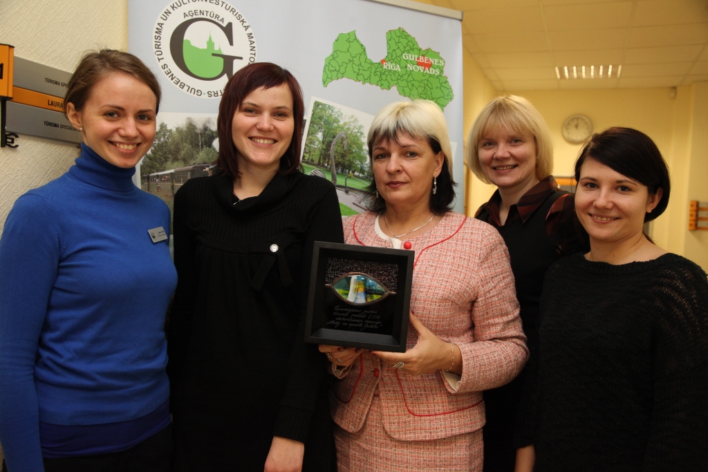 Latvijas tūrisma foruma laikā pagājušajā piektdienā tika nosaukti trīs veiksmīgākie jaunie Latvijas tūrisma produkti. Veiksmīgākā jaunā tūrisma produkta balvu saņēma arī ekskursija ar elektrovilcieniņu pa Gulbeni. Pašvaldības aģentūras “Gulbenes tūrisma un kultūrvēsturiskā mantojuma centrs” kolektīvs – Laura Lulle (no kreisās), Kristīne Nečajeva, Iveta Kovtuņenko, Līga Langrate un Marta Ludborža - saka vislielāko paldies visiem, kas atbalstīja aģentūras ideju par elektrovilcieniņu, devās ekskursijā ar to, kā arī piedalījās internetbalsojumā. “Mums ir liels prieks par Gulbenes uzvaru!” saka aģentūras direktore I.Kovtuņenko. 
Autors: Gatis Bogdanovs