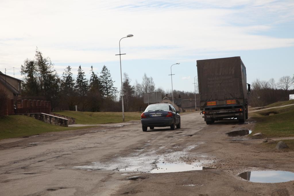 Cita pie citas Baložu ielā veidojas lielākas un mazākas bedres, un iela kļūst arvien neizbraucamāka. 	
Autors: Evita Brokāne