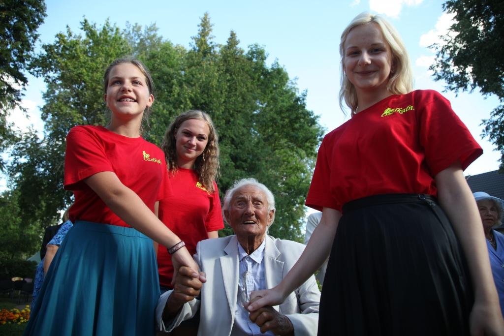 “Meitenes, es esmu tikai Goda virsdiriģents! Es tikai varu vadīt, ne vairs diriģēt,” saka kordiriģēšanas dižgars Gido Kokars, kurš savas 94. dzimšanas dienas priekšvakarā atkal ciemojās savu jaunu dienu zemē Beļavas pagasta Ozolkalnā, lai piedalītos sadziedāšanās pasākumā “Plecu pie pleca”. Iespēju nofotografēties kopā ar izcilo novadnieku izmantoja brīvprātīgā darba veicējas (no kreisās) Megija Ķiploka, Sanda Brūniņa un Lauma Lāce.
Autors: Gatis Bogdanovs