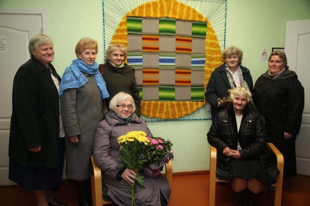 Beļavas pagasta rokdarbnieču kopas “Dzīpariņš” dalībnieces kopā ar savu vadītāju Herundu Zušu un pašu rokām darināto gobelēnu “Saules lakatiņš”. 	
Autors: Gatis Bogdanovs