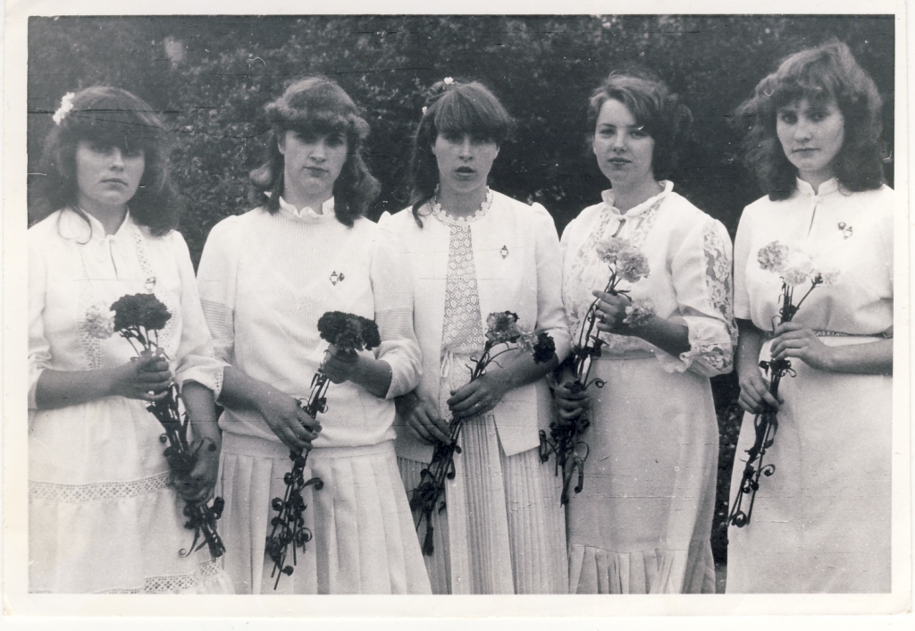 Baltās kleitas 1985.gada izlaidumā Gulbenes vidusskolā. Saldie astoņdesmitie - plisējumi, gofrējumi, volāni, mežģīnes, augstas krādziņas. Rokās absolventēm neiztrūkstoši – neļķes, tās gan bijis ļoti grūti dabūt. Daudzām meitenēm bija vienādas baltas kurpes, kas pa blatu tika izcīnītas toreizējā “unītī”.    
Autors: no personiskā albuma