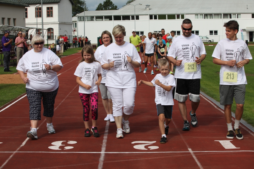 Pirmo reizi Viktora Kazāka piemiņas sacensību atklāšanā Gulbenē 300 metru goda apli, slavējot simtgadnieku, soļoja arī Viktora meita Maija Dauškane (no kreisās), mazdēls Madars Dauškans ar dzīvesbiedri Rasu (centrā), mazmeita Iveta Kazāka, mazbērni Rūdolfs Grants (pirmais no labās; viņš speciāli bija atlidojis uz Latviju no ASV, kur tagad dzīvo, mācās un sporto), Anna Sofija un Jānis Dauškani. 
Autors: Gatis Bogdanovs 