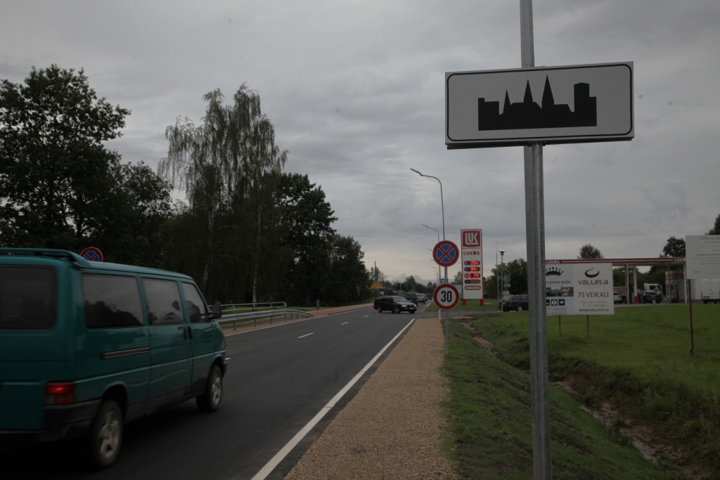 Norādījuma zīme “Apdzīvotas vietas sākums” mudina transportlīdzekļa vadītājus savaldīt savu spēkratu ātrumu līdz 50 kilometriem stundā. 	
Autors: Gatis Bogdanovs