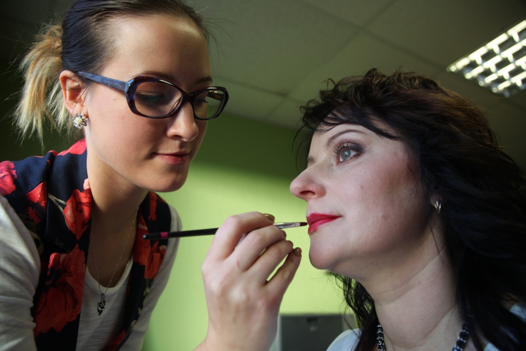 Vizāžiste Laura Aizkalniete: “Ikdienā Gunta nelieto daudz kosmētikas. Tā kā darbs bērnudārzā sākas ļoti agri, meikapam nav laika, tāpēc šajā reizē izvēlējos Guntai veidot klasisku vakara meikapu, kas noderētu svinīgiem pasākumiem.
Sākumā tika attīrīta seja un pielabota uzacu forma. Guntai ir sausa un mazliet apsārtusi sejas āda vaigu zonā, tāpēc pamatā lietoju mitrinošo meikapa bāzi. Lai nomaskētu vaigu apsārtumu, pēc mitrinošas bāzes izmantoju biezo korektoru, kas speciāli paredzēts apsārtumu nomaskēšanai. Pēc korektora lietošanas nepieciešamajās vietās uzklāju tonālo krēmu sejas toņa izlīdzināšanai. Tonis tonālajam krēmam tika lietots visgaišākais, jo Guntas āda ir gaiša. Svarīgi uzklāt tonālo krēmu tādā pašā tonī vai par vienu toni gaišāku nekā sejas āda, bet nekādā gadījumā tumšāku, jo tas rada mākslīgu un vecāku izskatu. Mazliet ietonēju zonu zem vaigu kaula ar tumšu krēmveida modelētāju un krēmveida vaigu sārtumu klāju tieši uz vaigu kaula. Guntai ir ovāla sejas forma, tāpēc īpaša sejas modelēšana nav vajadzīga. Guntas acis ir dziļas ar izteiktu locījuma līniju, tāpēc izvēlējos klāt gaiši rozā satīna toni pa visu plakstiņu un acs ārējo stūri iezīmēju tumšāku. Ēnām izvēlējos plūmju toni, kas piestāv jaunajai Guntas matu krāsai un tēlam kopumā. Lūpas - koši sarkanā tonī, kas, manuprāt, vienmēr ir modē. Šobrīd modē ir Merilinas Monro stils, kuram pat nav jāvelta ļoti daudz laika - pietiek uzklāt koši sarkanu lūpu toni, skropstu tušu un mazliet ietonēt acs locījuma līniju ar brūnu toni. Šo tēlu lieliski var veidot ikdienā, jo sarkanas lūpas jebkuru pelēku rudens dienu var padarīt košāku un dzīvīgāku.”
Autors: Gatis Bogdanovs