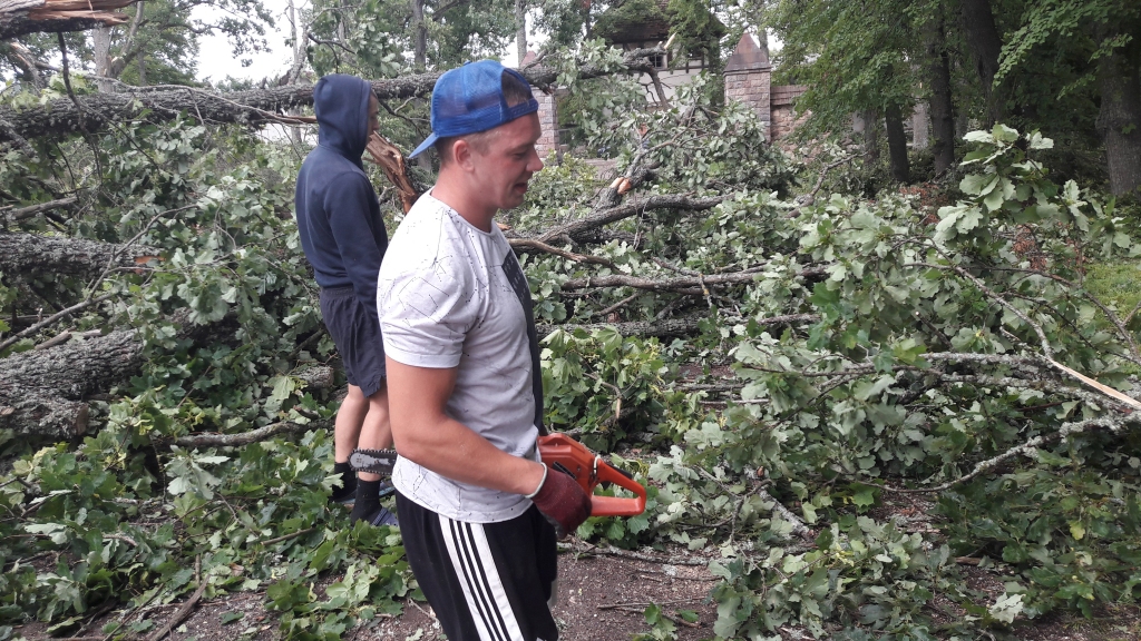 “Neviens mūs nesauca, bet kādam taču ir tas jānovāc,” saka jaungulbenietis Raivis Pētersons, kurš kopā ar draugu Arnoldu Ķīsi svētdien ķērās pie zāģa, lai attīrītu ceļu uz pili, kur kā nopļauti gulēja koki. Daudzi jaungulbenieši zāģēja un nesa zarus visu svētdienu, lai novērstu vētras posta darbus. 
Autors: Ginta Alberte