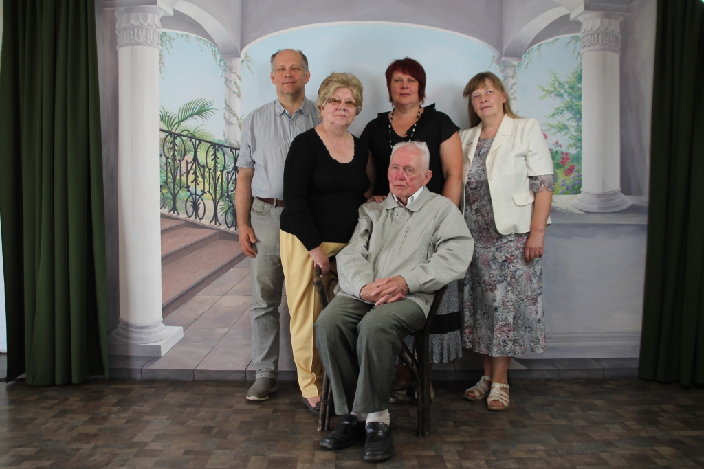 Jānis Knoks (sēž) ar dzīvesbiedri Astrīdu (no kreisās), meitu Gintu (vidū) un dēlu Māri augustā nofotografējās Tirzas tējnīcā pie sienas, kura apgleznota tāpat, kā kādreiz bijusi Ferdinanda Knoka fotodarbnīcā. 
Autors: Kārlis Dzenis