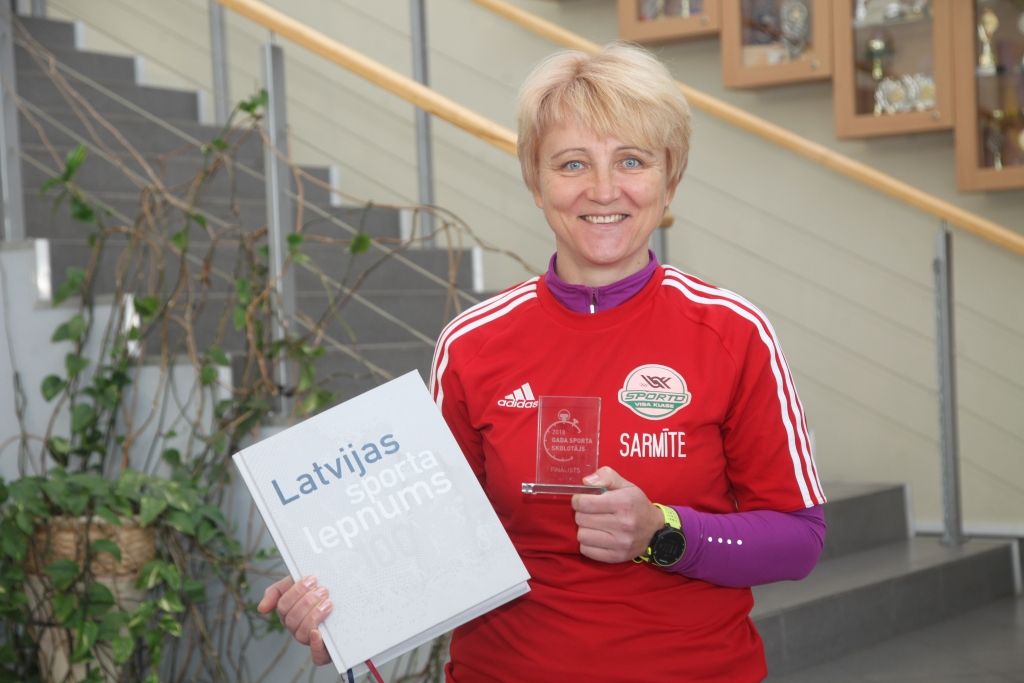 Kā konkursā “Gada sporta skolotājs 2018” fināliste Sarmīte Gobiņa saņēma dāvanā grāmatu “Latvijas sporta lepnums”, kurā lasāmi stāsti par svarīgākajiem notikumiem un personībām Latvijas sporta vēsturē.    
Autors: Gatis Bogdanovs