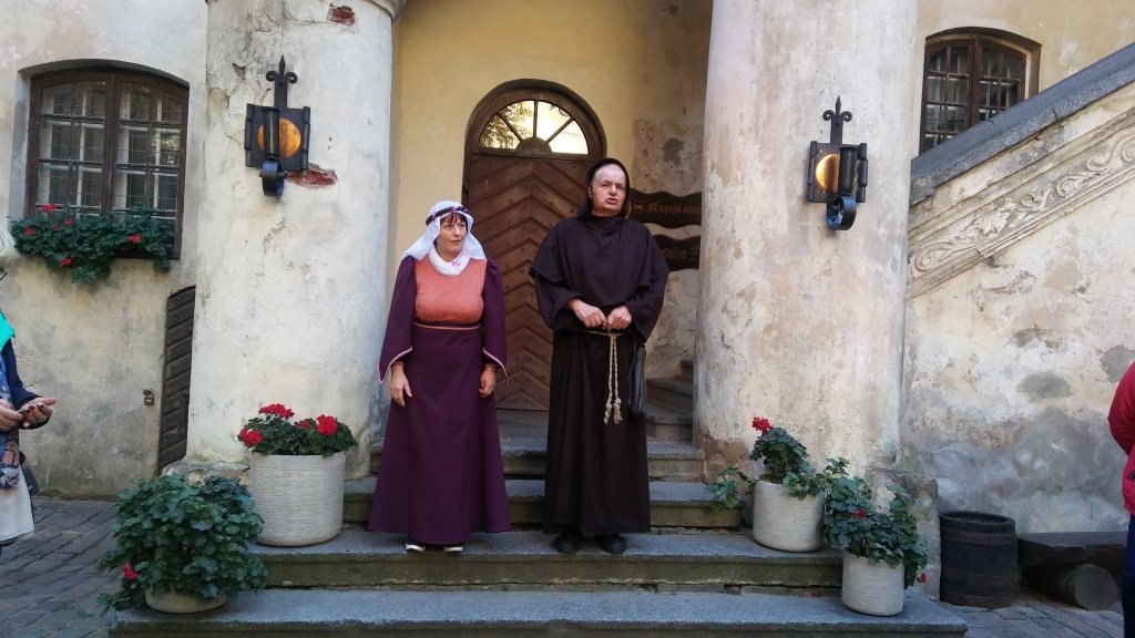 Jaunpils pils pagalmā sagaida brālis Teodors un kalpone Mārīte, lai atraktīvi un ar humoru izrādītu pils zāles un vīna pagrabu. 
Autors: Pārsla Konrāde