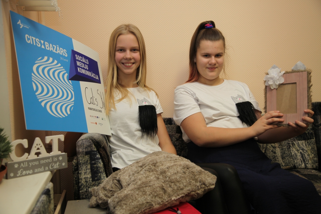 Jaunajām uzņēmējām Lotei Sniķei un Annija Cīrulei ideju netrūkst. “Dzirksteles” redakcijā abas ieradās stilīgos T-kreklos. “Mums ir preču dažādība, bet mēs apspriežam domu par oriģināliem krekliem ar pūkainu kabatu, no kuras ārā raugās kaķis,” saka Lote.  
Autors: Gatis Bogdanovs