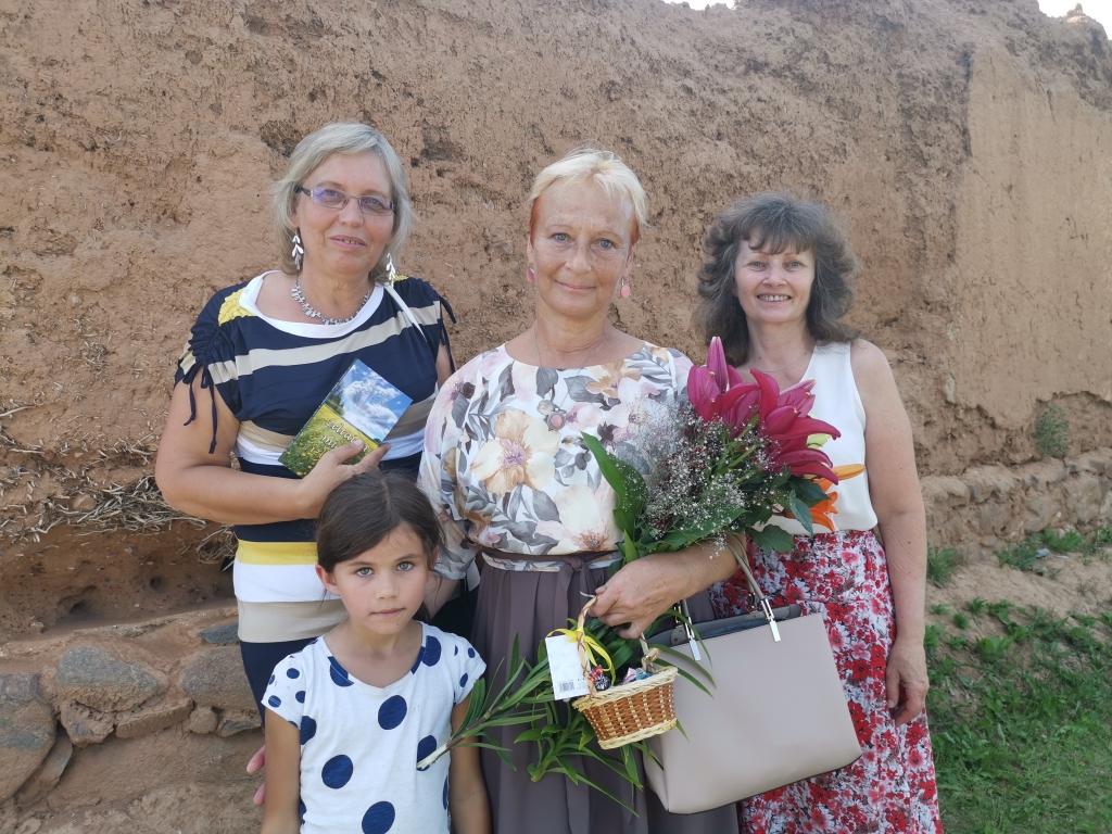 Krāsaini un sirsnīgi ar dažādiem pasākumiem sestdien, 18. jūlijā Jaungulbenē tika aizvadīta pagasta Saimes diena. Pēcpusdienā gan vietējie pagasta iedzīvotāji, gan tālāki ciemiņi pulcējās Rijas kalnā dzejnieces Ineses Toras (centrā) jaunās dzejas grāmatas “Zeltaina migla izlijusi” atvēršanas svētkos. “Tā ir mana dzimtās vietas smalkā izjūta dzejā un tā ir dabas un cilvēka mijiedarbība,” jauno izlasi raksturo pati dzejniece, kurai kopā jau izdotas divpadsmit dzejas grāmatas. No Limbažiem atbraukusī Alda Treija (no kreisās) ļoti novērtē dzejnieces talantu un viņas dzejas rindas vairākkārt ietērpusi mūzikā. “Ne katra dzejnieka rindas var ietērpt melodijā. Tie vārdi ir ļoti aizkustinoši. Man pašai bija reiz emocionāls brīdis dzīvē, es toreiz izlasīju Ineses dzeju un, apsēžoties pie klavierēm, īstā melodija radās pati no sevis,” atklāj A.Treija. “Esmu priecīga Inesi Toru šodien te dzirdēt,” atzīst Ineta Jūga no Galgauskas. Kopīgu valodu dzejniece atrod arī ar mazo lasītāju Abigailu no Līgo pagasta. 	
Autors: Viktorija Slavinska-Kostigova