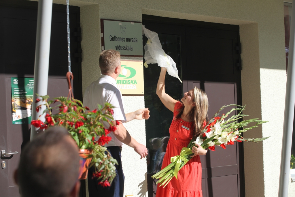 Kolektīva saliedēšanas svētki trešdien, 19.augustā, notika Gulbenē pie novada vidusskolas ēkām. Plāksne ar uzrakstu “Gulbenes novada vidusskola” svinīgi tika atklāta divās pilsētas adresēs – Līkajā ielā 21 un Skolas ielā 10. Attēlā plāksni Līkajā ielā 21 atklāj vidusskolas direktore Linda Ūdre-Rizga un domes priekšsēdētāja vietnieks Andis Caunītis. Viss skolas pedagogu un personāla kolektīvs bija aicināts kopā pulcēties vispirms vienā, pēc tam otrā adresē. Pēc svinīgajām pasākuma daļām sekoja saviesīgā sadraudzība ar spēles elementiem, mūziku, cienastu. 	
Autors: Gatis Bogdanovs