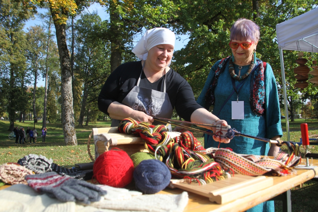 “Tas mākslinieka radītais darbs ar tā pirksta pieskārienu visos laikos tomēr ir bijis visvērtīgākais,” šie Gulbenes novada vēstures un mākslas muzeja direktores Valdas Vorzas vārdi attiecas ne tikai uz glezniecības mākslas darbiem, bet uz katru ar rokām izloloto darbu, ko varēja aplūkot nedēļas nogalē 3. starptautiskajā mākslas festivālā “Divi Jūliji 2020”. Vecgulbenes muižas parkā un klētī radošajās aušanas, mezglošanas, filcēšanas, flīžu dekorēšanas darbnīcās darbojās un jaunas prasmes apguva 247 apmeklētāji. Attēlā – Lizuma amatnieku kopas pārstāve rāda celaiņu aušanu. Viņai līdzās māksliniece Laima Bakāne, kuras autortehnikas darbus varēs vēl līdz 24.oktobrim aplūkot Sarkanajā pilī.		
Autors: Gatis Bogdanovs