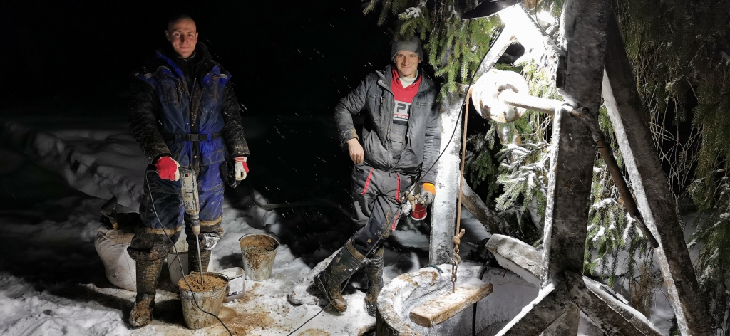 “Jānis Blumbergs (no kreisās) un Aigars Alksnis no Rankas pēdējo gadu laikā kopā izrakuši vairāk nekā trīsdesmit aku. Cik iztīrītas – skaits jau sajucis. Uzkrātas gan zināšanas, kā darbu veikt, gan rastas atbildes, kas visbiežāk izraisa ūdens trūkumu māju akās. Attēlā abi vēlākā vakara stundā sākuši tīrīšanas darbu kādā akā Jaungulbenē. 
Autors: Viktorija Slavinska-Kostigova