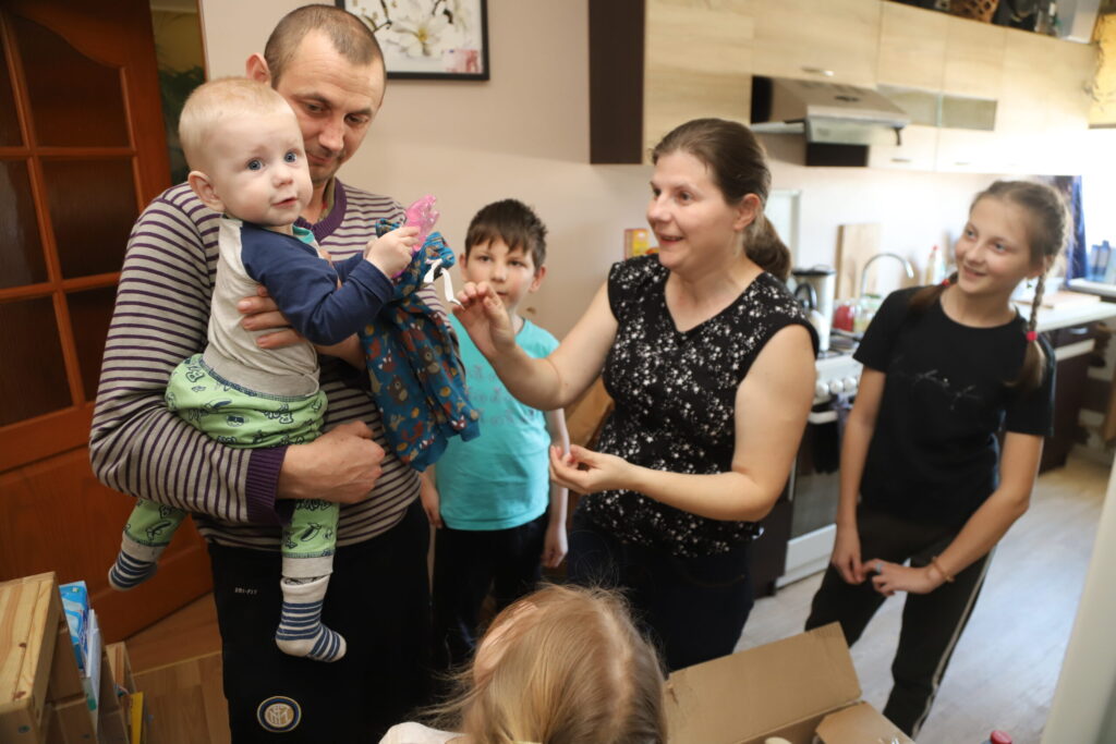 Lūk, viena mantiņa zobiem, kuru var pakošļāt, lai ātrāk mazajam Aleksejam izaug pirmie zobiņi. Tēta Aleksandra rokās mazajam ir droši. Un blakus ir arī mamma Oļa, mazā māsa Ilona, lielā māsa Katja un vecākais brālis Nikolajs. Kemiņu ģimene Lizumā jūtas droši. 
Autors: Foto: Gatis Bogdanovs